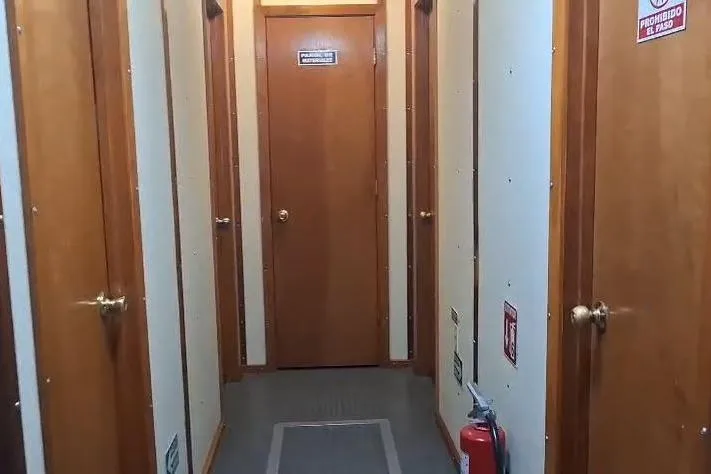  Yacht Photos Pics Hallway inside a 2009 custom-built offshore crew vessel, featuring wooden doors and a fire extinguisher.