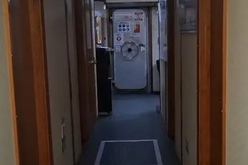  Yacht Photos Pics Interior hallway of a 2009 custom-built offshore crew vessel, featuring a secure door.