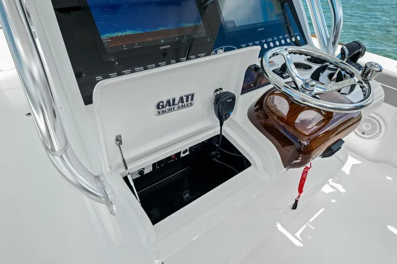 Galati Yacht Sales Trade Yacht Photos Pics 2025 Valhalla Boatworks V-37 helm with steering wheel, navigation screens, and storage compartment.