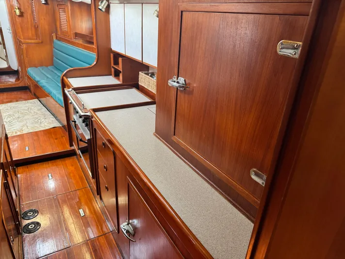 Dream Catcher Yacht Photos Pics Interior of 1995 Hylas 46 yacht with wooden cabinetry and teal seating.