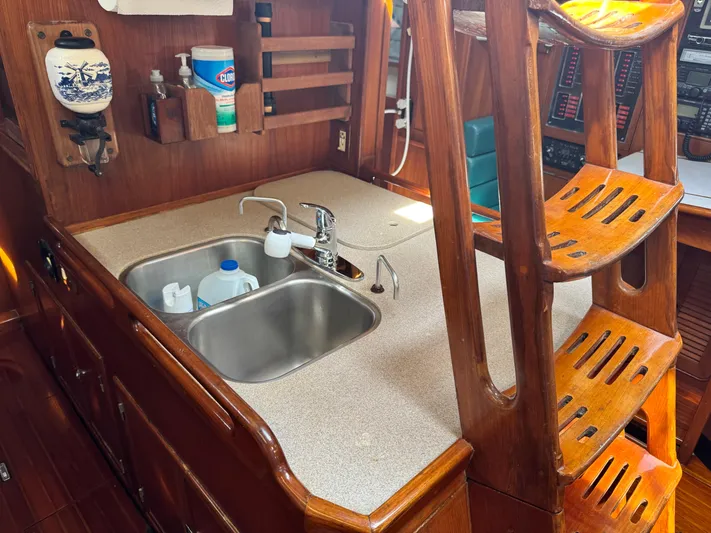 Dream Catcher Yacht Photos Pics Wooden interior of a 1995 Hylas 46 yacht featuring a compact kitchen with a double sink.