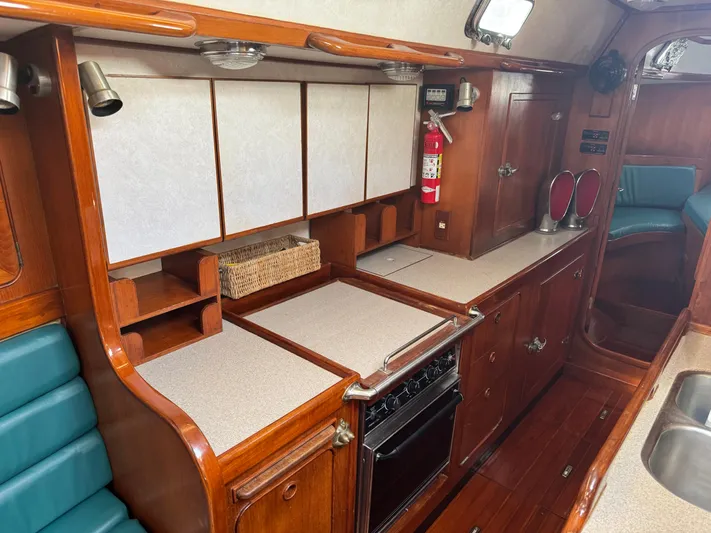 Dream Catcher Yacht Photos Pics Interior of 1995 Hylas 46 yacht kitchen with wood cabinetry and modern appliances.