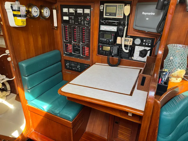 Dream Catcher Yacht Photos Pics Navigation station on a 1995 Hylas 46 yacht with control panels and seating.
