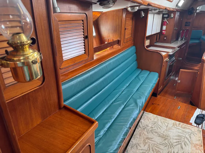 Dream Catcher Yacht Photos Pics Interior of a 1995 Hylas 46 yacht with wooden finish and teal seating.