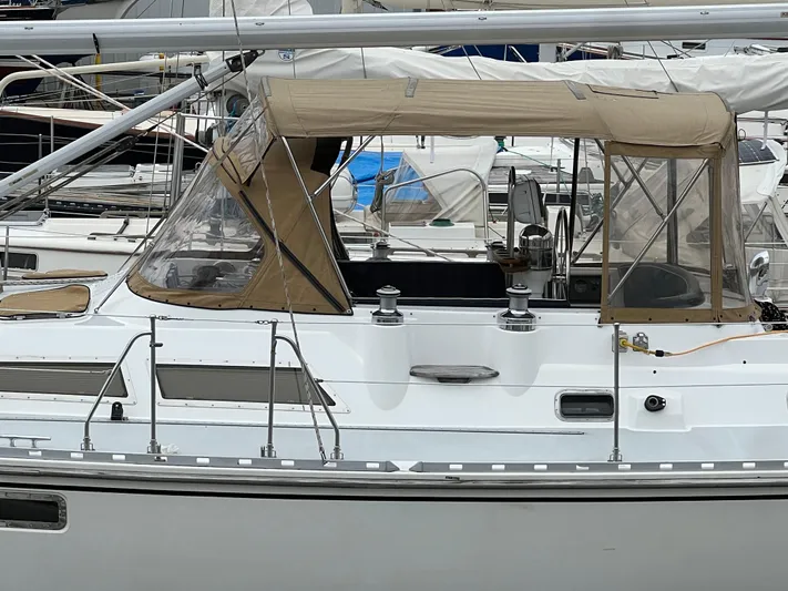Dream Catcher Yacht Photos Pics Sailboat Hylas 46, 1995 model, docked with beige canopy and sleek white hull.