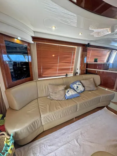  Yacht Photos Pics Luxurious interior of 2009 Sea Ray 58 Sedan Bridge with beige leather sofa and wooden accents.