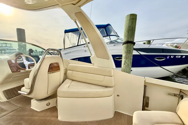  Yacht Photos Pics 2022 Chris-Craft Launch 25 GT interior with elegant seating and steering wheel, docked beside another boat.