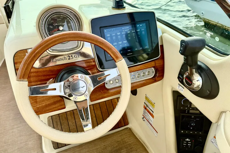  Yacht Photos Pics 2022 Chris-Craft Launch 25 GT dashboard with wooden steering wheel and modern controls.
