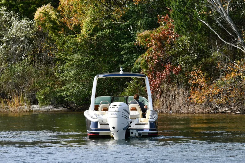  Yacht Photos Pics 2022 Chris-Craft Launch 25 GT boat cruising on a lake with autumn foliage.