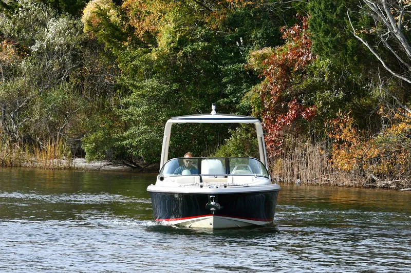  Yacht Photos Pics 2022 Chris-Craft Launch 25 GT boat cruising on a scenic lake with autumn foliage.