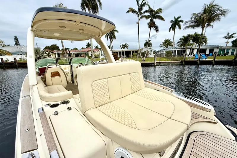  Yacht Photos Pics 2022 Chris-Craft Launch 25 GT boat with luxurious seating, docked by palm trees.