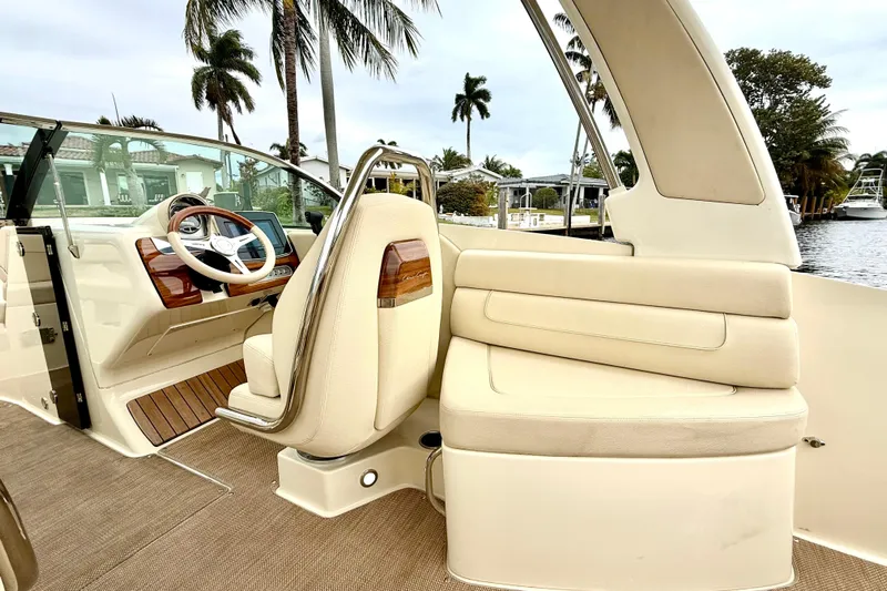  Yacht Photos Pics 2022 Chris-Craft Launch 25 GT interior with elegant seating and steering, docked by palm trees.