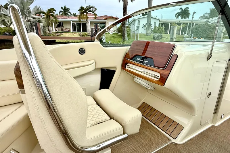  Yacht Photos Pics 2022 Chris-Craft Launch 25 GT interior with beige seating and wooden dashboard accents.