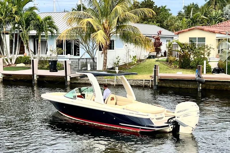  Yacht Photos Pics 2022 Chris-Craft Launch 25 GT boat cruising near waterfront homes with palm trees.