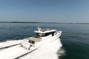 Stock 5 Yacht Photos Pics 2024 Axopar 45 boat cruising on open water, showcasing sleek design and powerful engines.