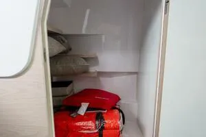Stock 5 Yacht Photos Pics Storage compartment in 2024 Axopar 45 boat, featuring cushions and life jackets.