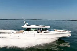Stock 5 Yacht Photos Pics 2024 Axopar 45 boat cruising on open water under clear blue skies.