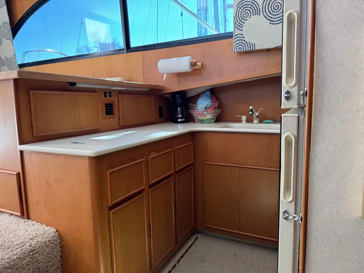  Yacht Photos Pics Interior of a 1998 Post 42 Convertible yacht kitchen with wooden cabinets and countertop.
