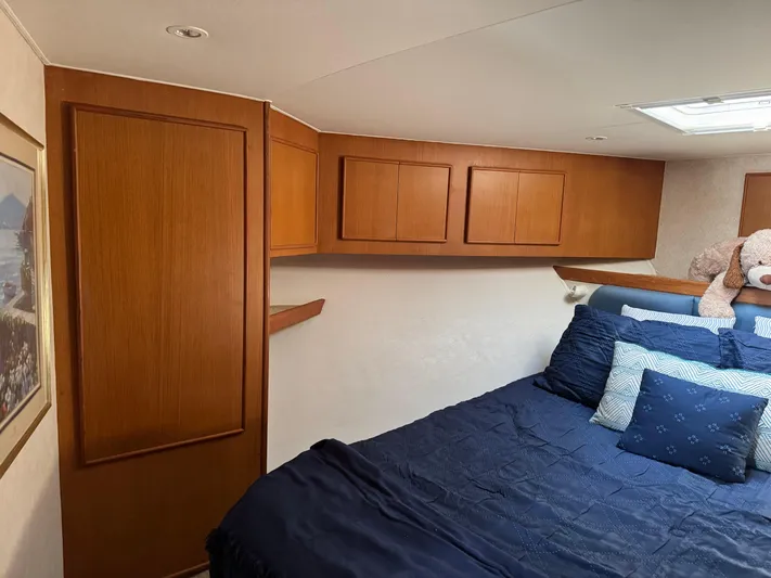  Yacht Photos Pics Cozy cabin interior of 1998 Post 42 Convertible with wooden cabinets and blue bedding.