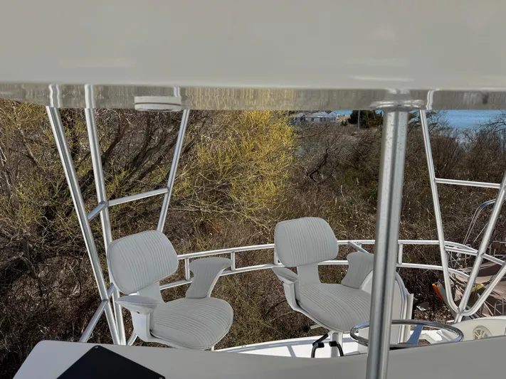  Yacht Photos Pics 1998 Post 42 Convertible yacht with white chairs on deck, surrounded by trees.