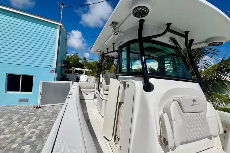  Yacht Photos Pics 2024 World Cat 325 CC boat docked near a blue building under a clear sky.