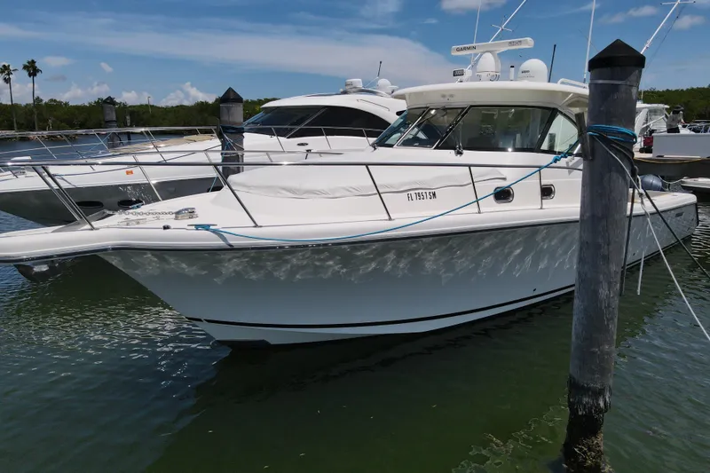  Yacht Photos Pics 2010 Pursuit OS 375 Offshore boat docked in a marina under a clear blue sky.