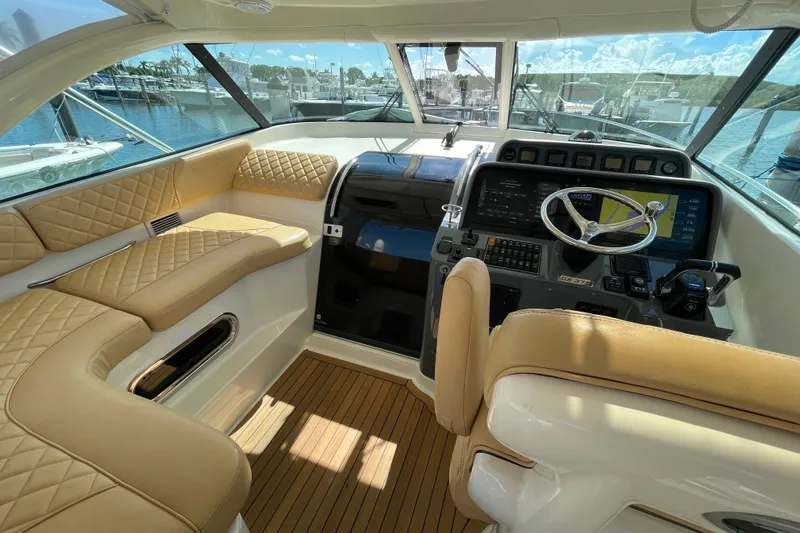  Yacht Photos Pics Luxurious interior of 2010 Pursuit OS 375 Offshore boat with leather seating and modern dashboard.
