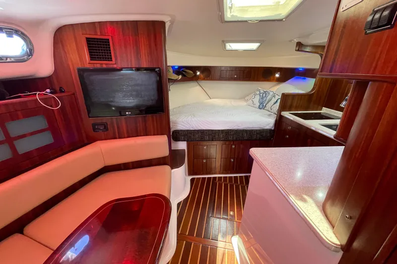  Yacht Photos Pics Luxurious interior of 2010 Pursuit OS 375 Offshore boat with cozy seating and bed.