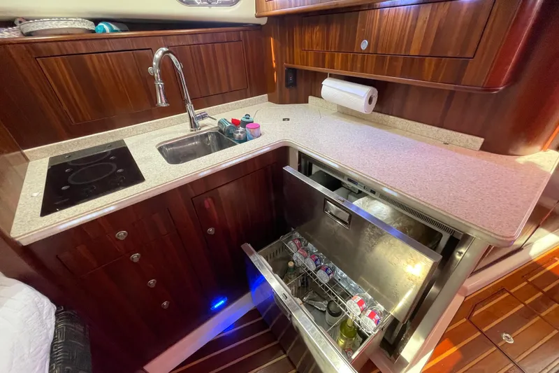  Yacht Photos Pics 2010 Pursuit OS 375 Offshore yacht kitchen with sink, stove, and open fridge drawer.