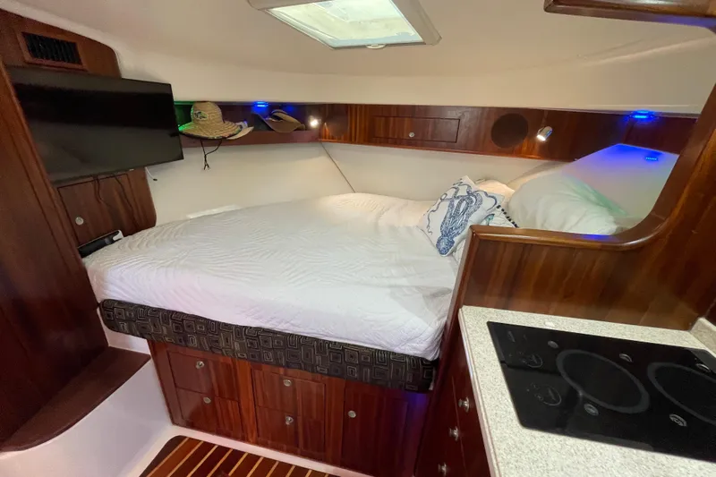  Yacht Photos Pics Luxurious cabin interior of 2010 Pursuit OS 375 Offshore boat with cozy bed and kitchenette.