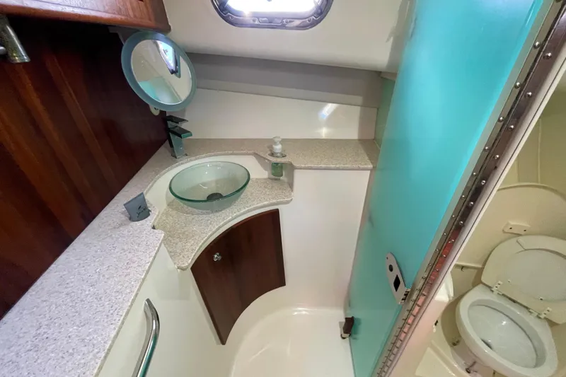  Yacht Photos Pics 2010 Pursuit OS 375 Offshore boat bathroom with glass sink and compact toilet.