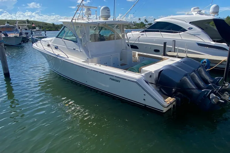  Yacht Photos Pics 2010 Pursuit OS 375 Offshore boat docked in a marina under clear blue skies.