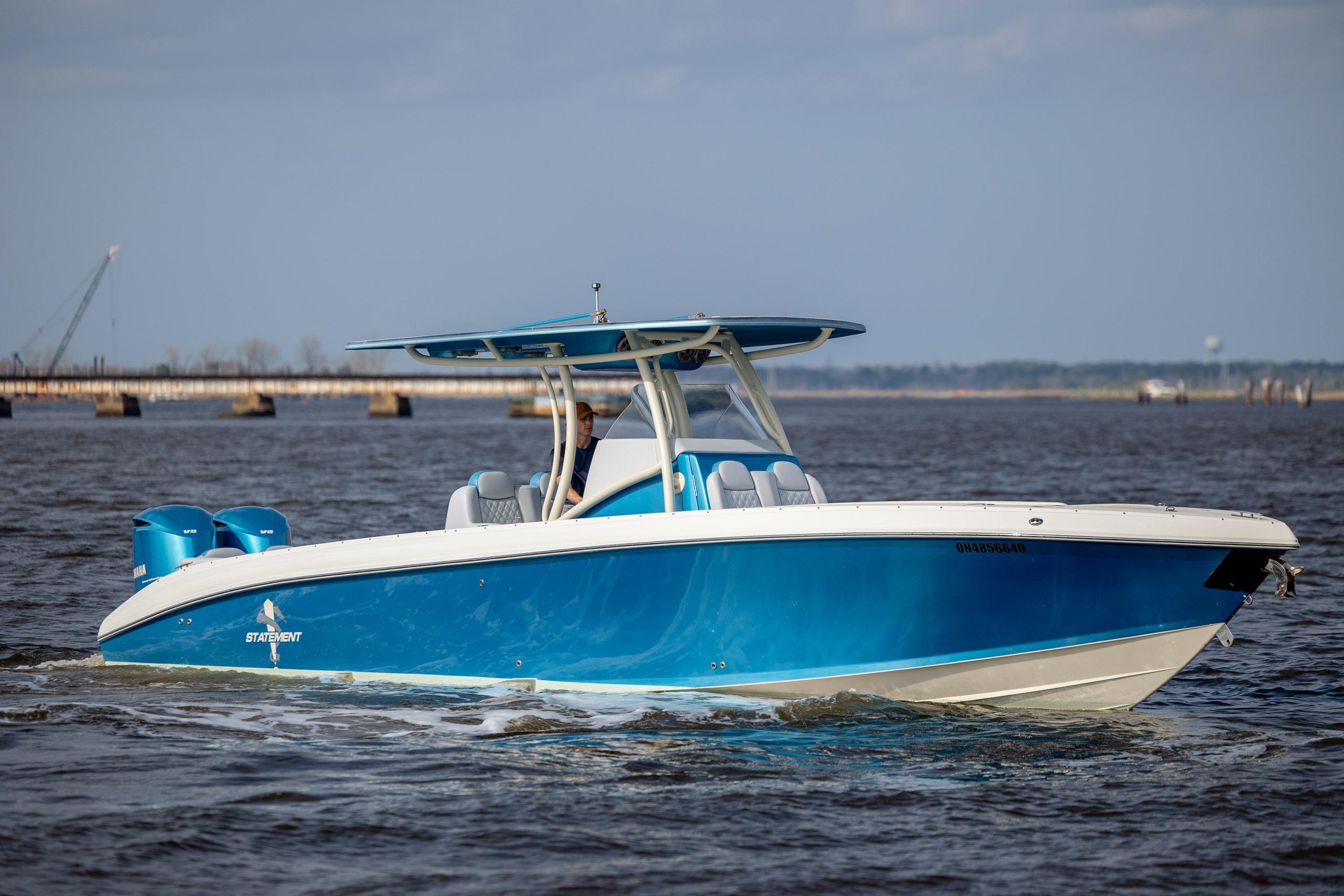 2014 Statement 350 Open boat cruising on water, featuring a sleek blue and white design.