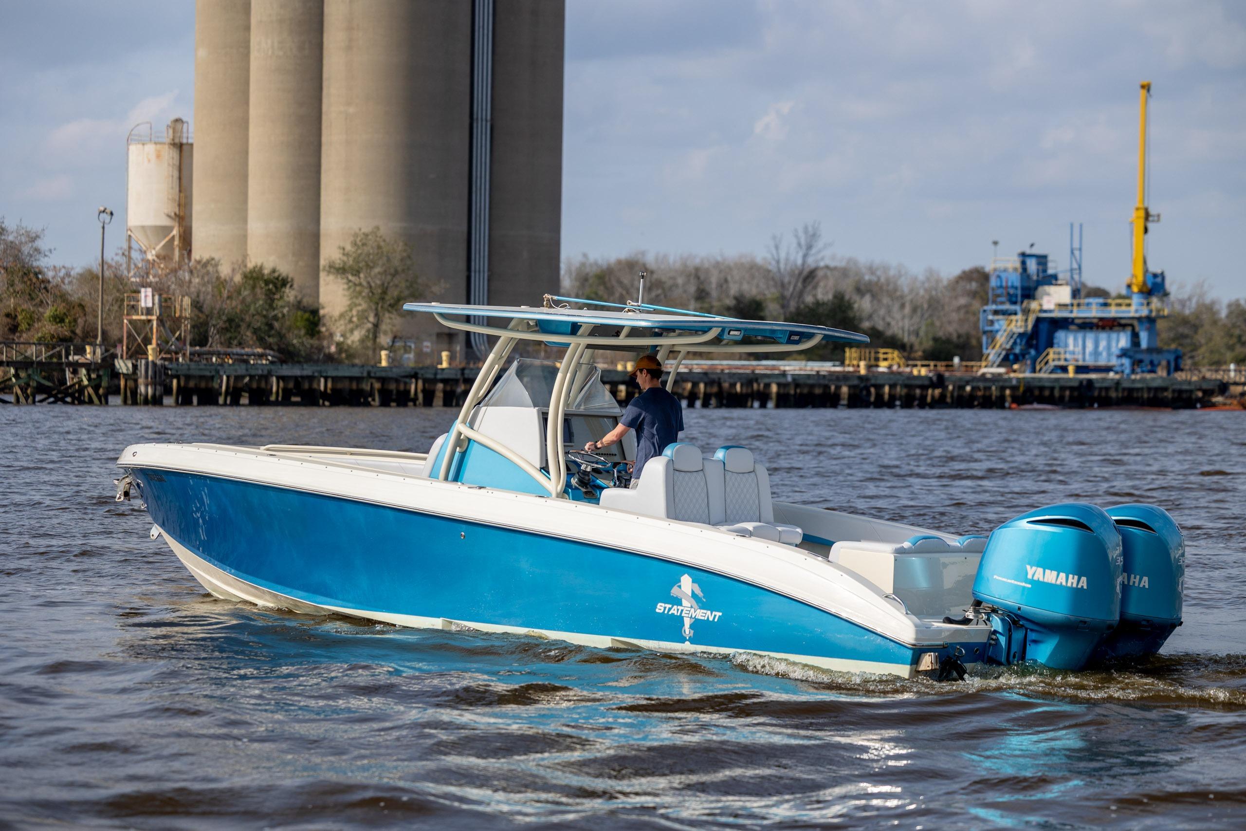 Blue 2014 Statement 350 Open boat with twin Yamaha engines on a river.