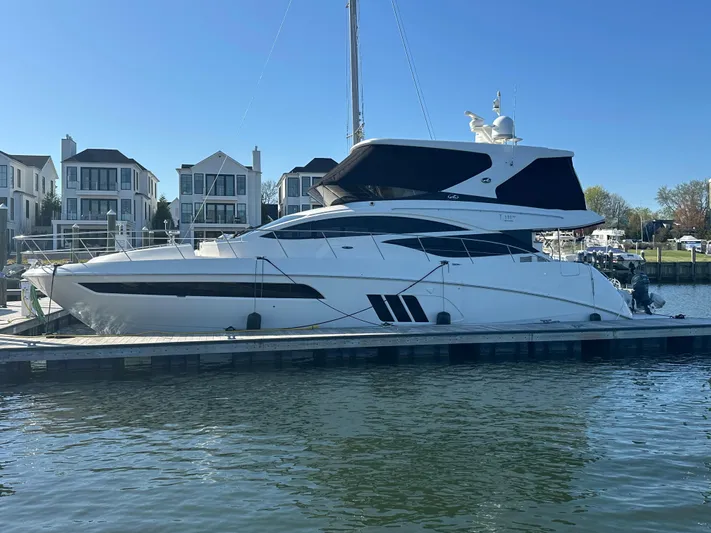 Working Late Yacht Photos Pics 2016 Sea Ray L590 Fly yacht docked at marina, with modern waterfront homes in background.