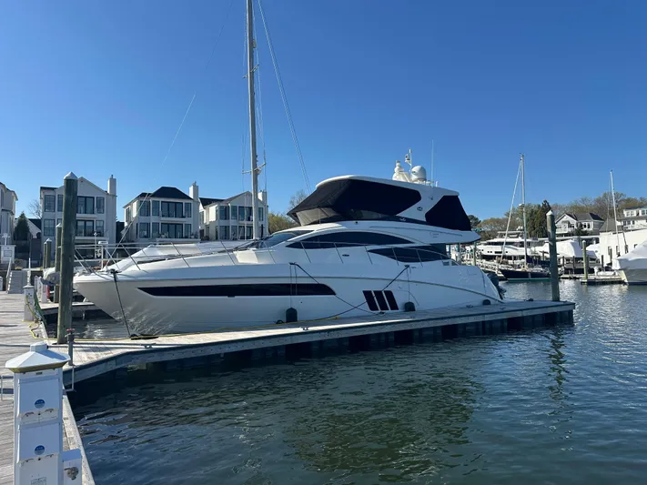 Working Late Yacht Photos Pics 2016 Sea Ray L590 Fly yacht docked at marina with waterfront homes in background.