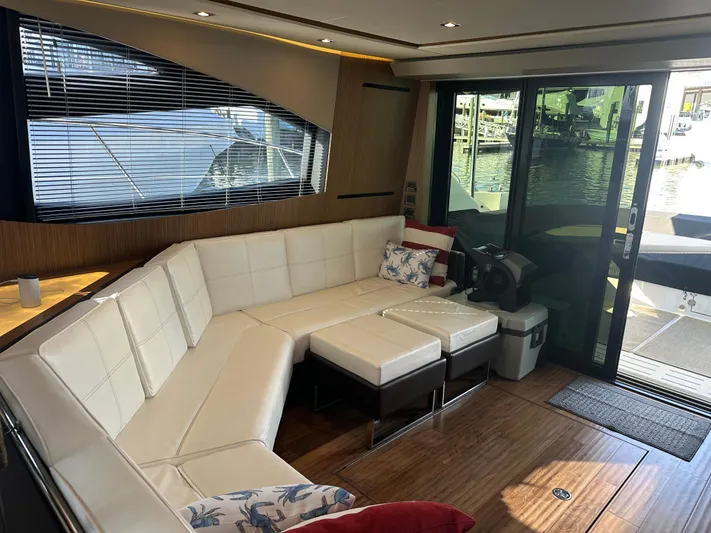 Working Late Yacht Photos Pics Luxurious interior of 2016 Sea Ray L590 Fly yacht with white leather seating and wood flooring.