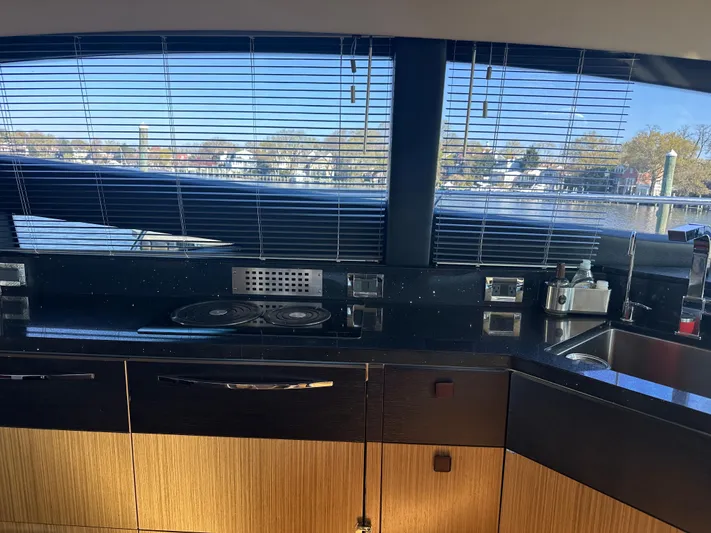 Working Late Yacht Photos Pics Interior view of 2016 Sea Ray L590 Fly yacht kitchen with sleek countertops and window blinds.