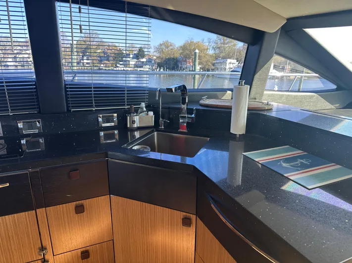 Working Late Yacht Photos Pics Luxurious kitchen interior of 2016 Sea Ray L590 Fly yacht with sleek countertops and modern fixtures.