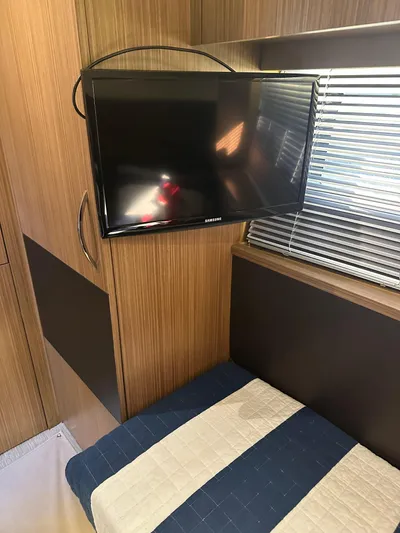 Working Late Yacht Photos Pics Interior of 2016 Sea Ray L590 Fly yacht with mounted TV and striped bedding.