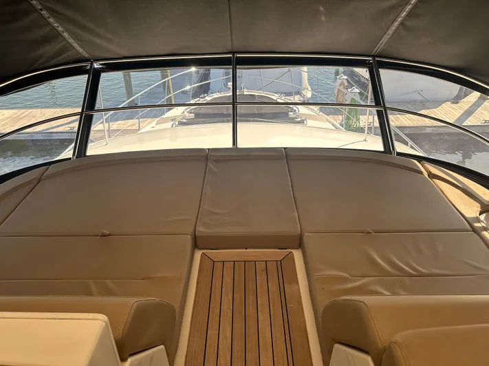 Working Late Yacht Photos Pics 2016 Sea Ray L590 Fly yacht interior with cushioned seating and wooden flooring.