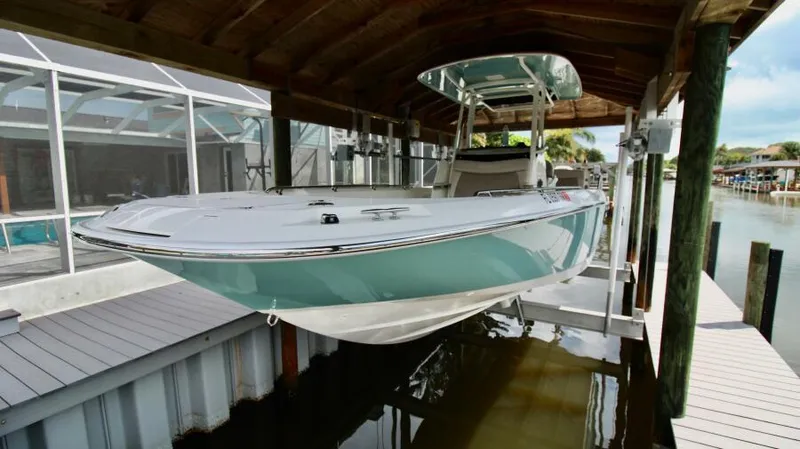 Yacht Photos Pics 2019 Boston Whaler DAUNTLESS boat docked under a wooden shelter.