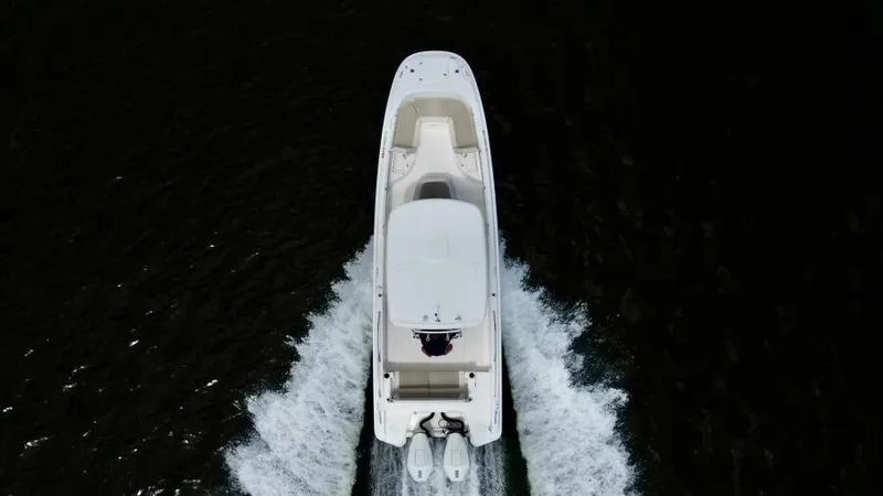  Yacht Photos Pics Aerial view of 2019 Boston Whaler DAUNTLESS boat cruising on dark water.