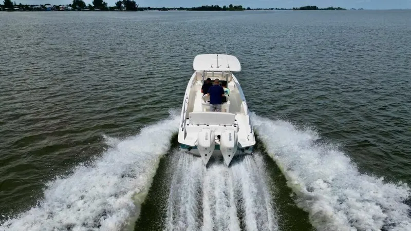  Yacht Photos Pics 2019 Boston Whaler DAUNTLESS cruising on open water, rear view.
