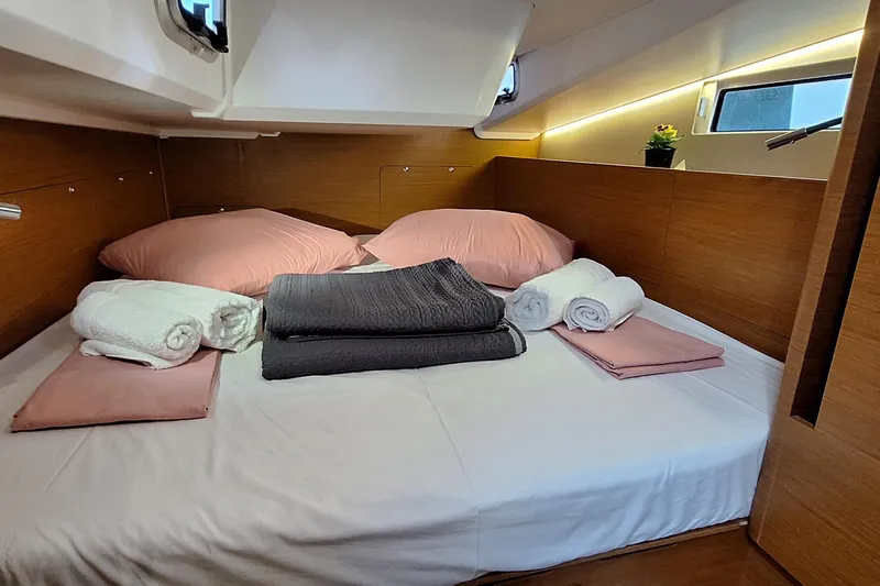  Yacht Photos Pics Cozy cabin interior of 2019 Jeanneau Sun Odyssey 490 with neatly arranged bedding.