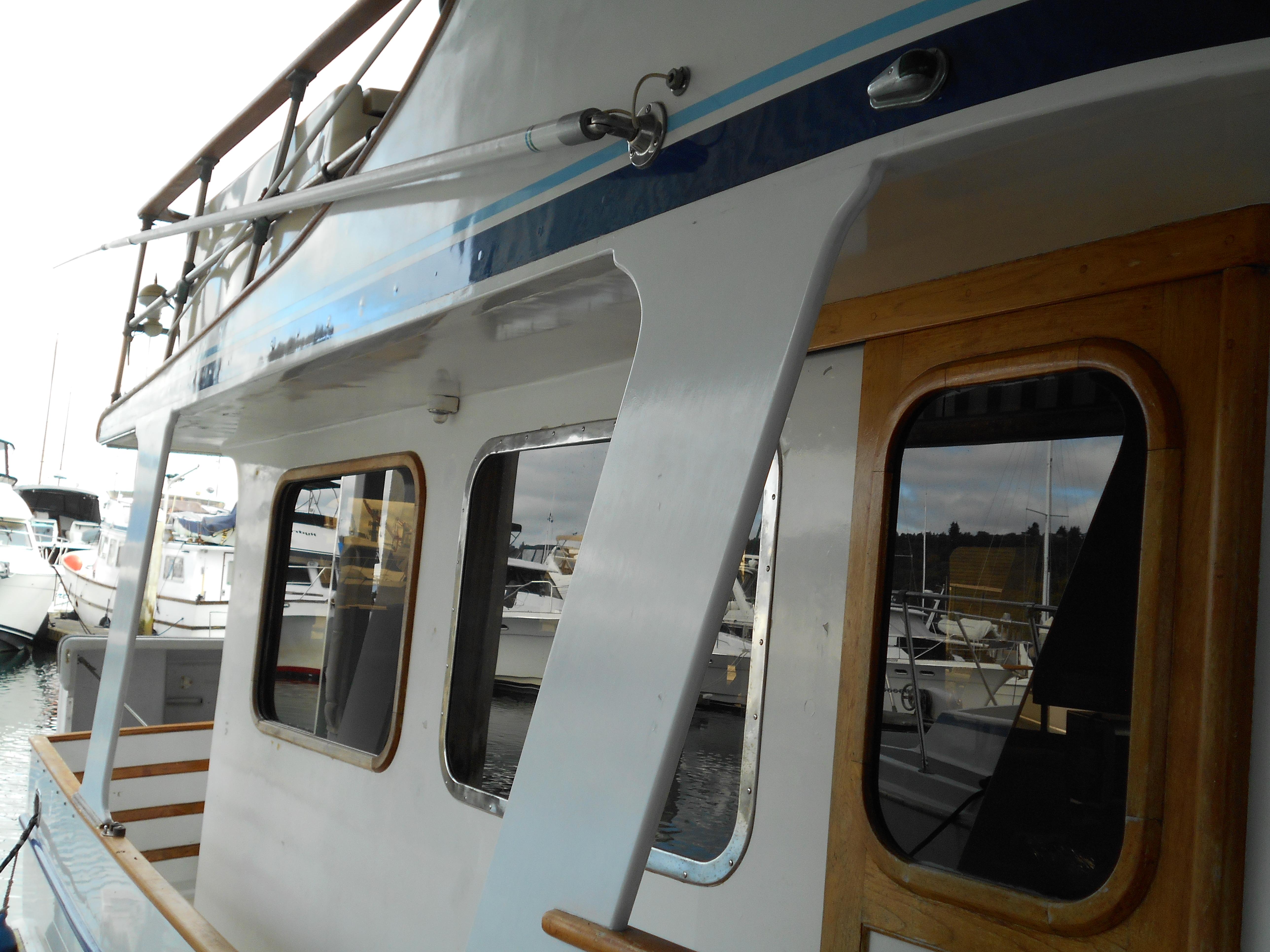 1977 Davis 42' boat docked, featuring wooden accents and large windows.