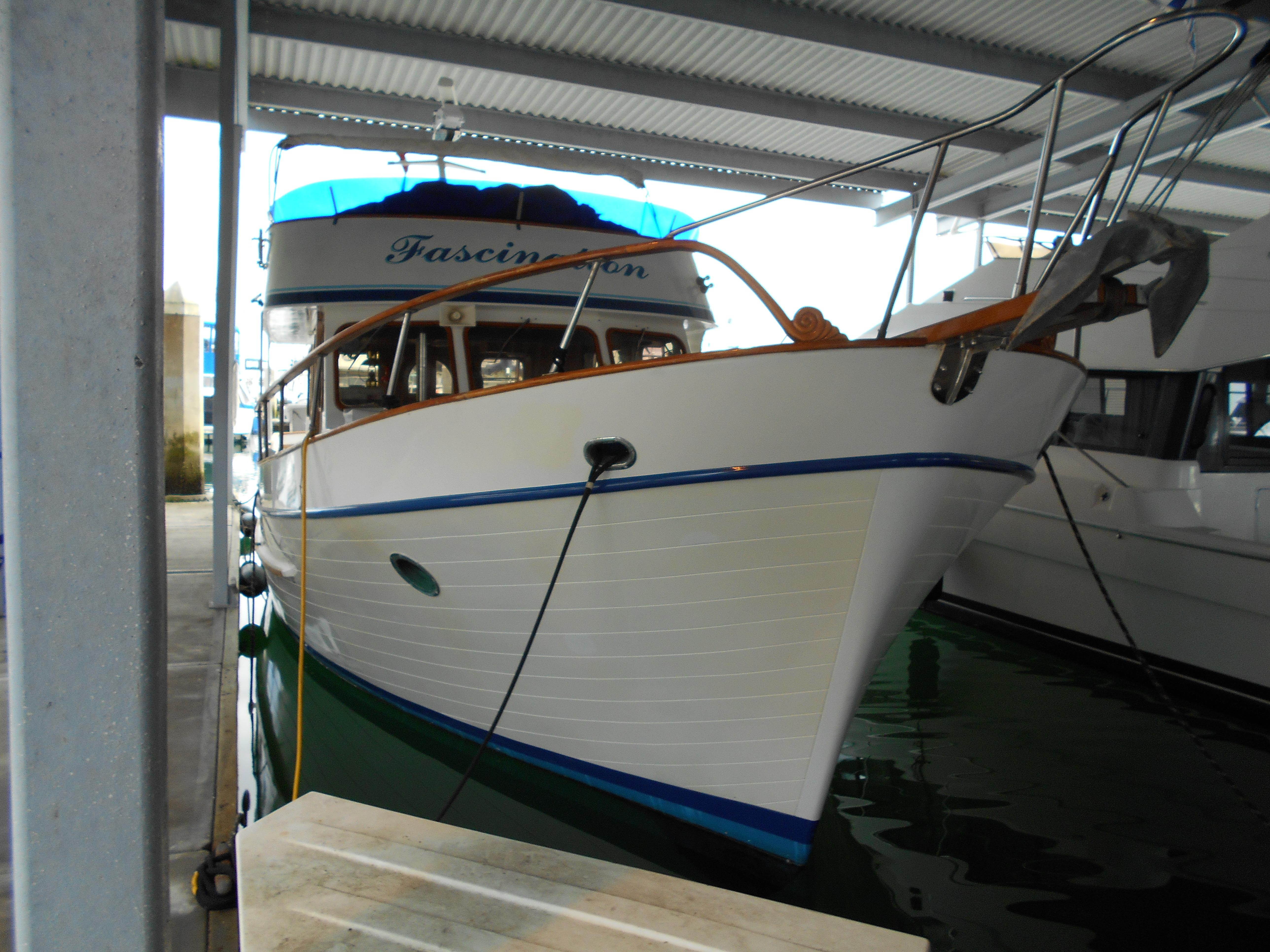 1977 Davis 42' boat docked under a covered marina.