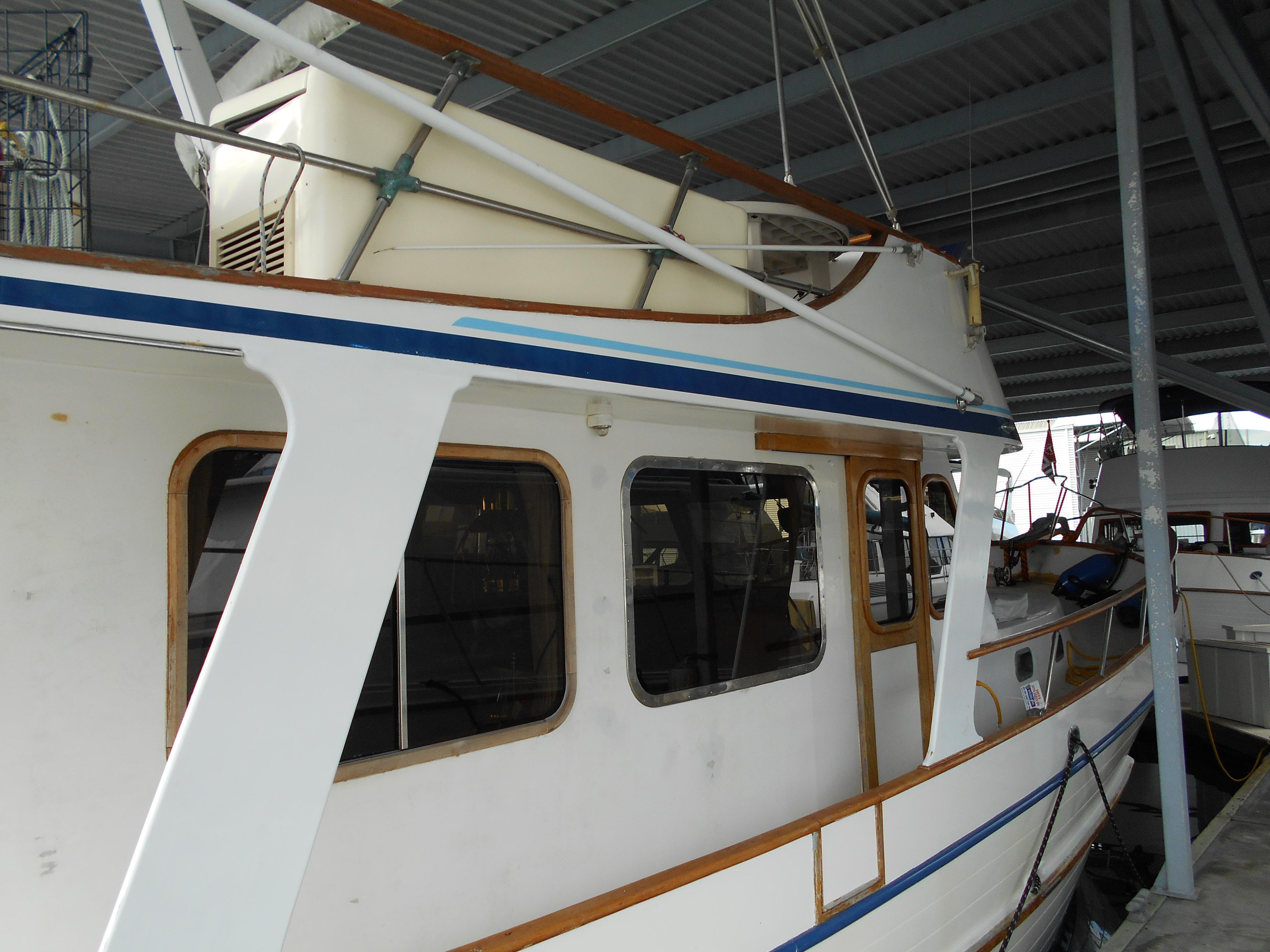 1977 Davis 42' boat docked under a covered marina.