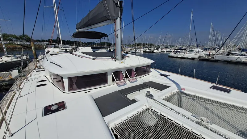  Yacht Photos Pics 2012 Lagoon 450 F catamaran docked in a marina, surrounded by sailboats.