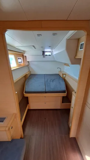  Yacht Photos Pics Interior cabin of 2012 Lagoon 450 F catamaran with cozy bed and wooden finish.
